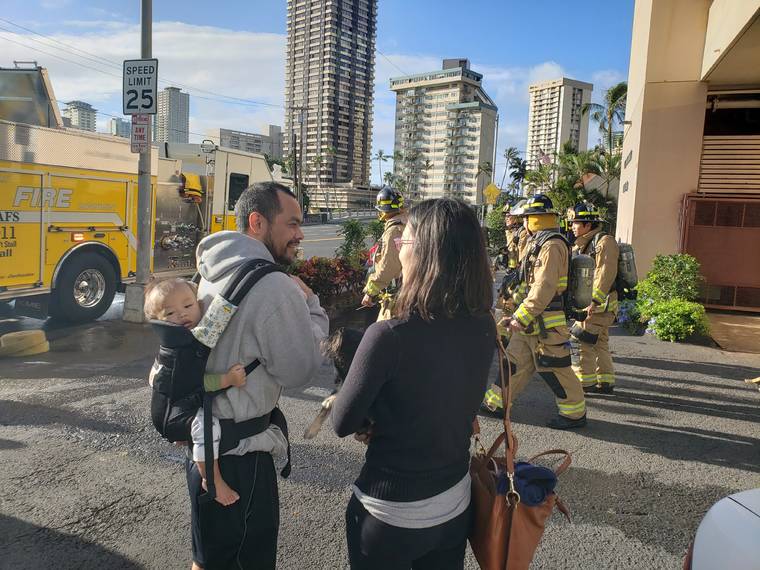 DENNIS ODA / DODA@STARADVERTISER.COM
                                Chad Goldstein, 10-month-old Evan Goldstein and Lisa Chau waited outside their Ala Wai Manor building as Honolulu firefighters battled a fire at the McCully condo.