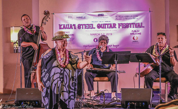COURTESY DON TOUCHI Festival emcee Lady Ipo Kahaunaele-Ferreira dances the hula while steel guitarist Greg Sardinha, center, performs with Adam Asing, left, and Kaipo Asing.