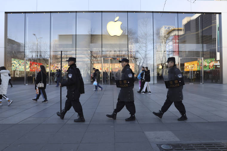 ASSOCIATED PRESS / MARCH 6                                Chinese security guards march past an Apple store in Beijing, China. Apple is temporarily closing its 42 stores in mainland China, one of its largest markets, as a new virus spreads rapidly and the death toll there rose to 259 today. The iPhone maker said in a statement it was closing stores, corporate offices and contact centers in China until Feb. 9 “out of an abundance of caution and based on the latest advice from leading health experts.”