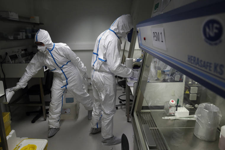 ASSOCIATED PRESS
                                French lab scientists in hazmat gear inserting liquid in test tube manipulated potentially infected patient samples at Pasteur Institute in Paris, today. Scientists at the Pasteur Institute developed and shared a quick test for the new virus that is spreading worldwide, and are using genetic information about the coronavirus to develop a potential vaccine and treatments.
