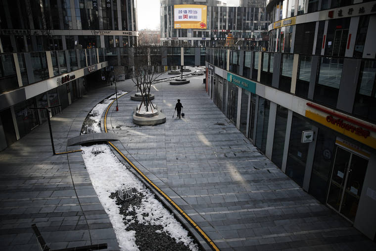 ASSOCIATED PRESS
                                A cleaner walks through a deserted compound of a commercial office building in Beijing.