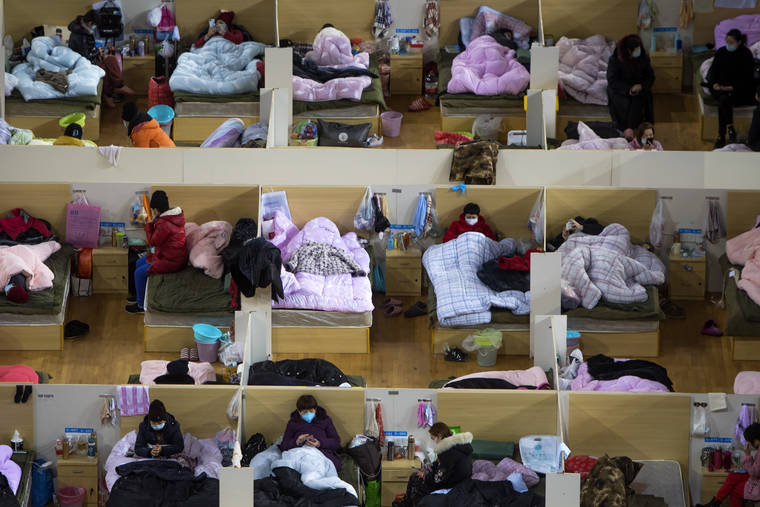 XIAO YIJIU/XINHUA VIA ASSOCIATED PRESS
                                Patients infected with the coronavirus rested at a temporary hospital converted from Wuhan Sports Center Monday in Wuhan in central China’s Hubei Province.