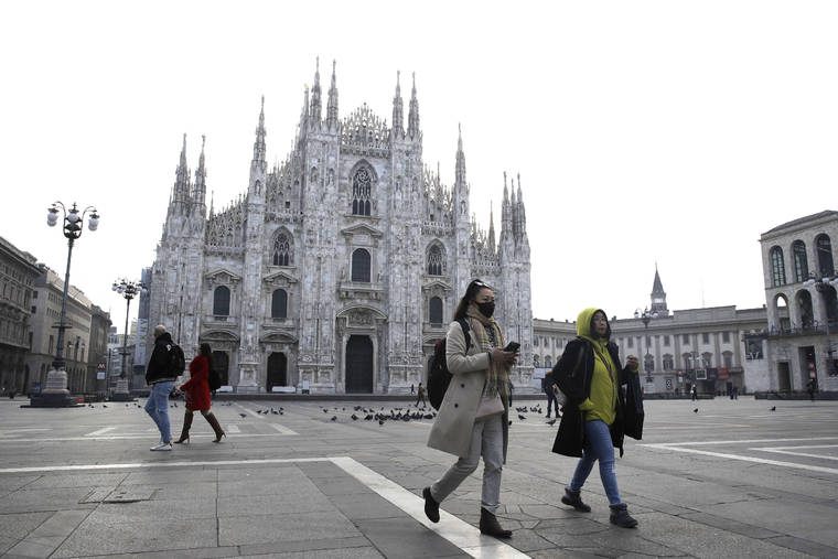 ASSOCIATED PRESS
                                A woman wearing a sanitary mask walks past the Duomo gothic cathedral in Milan, Italy, today. A dozen Italian towns saw daily life disrupted after the deaths of two people infected with the virus from China and a pair of case clusters without direct links to the outbreak abroad. A rapid spike in infections prompted authorities in the northern Lombardy and Veneto regions to close schools, businesses and restaurants and to cancel sporting events and Masses.