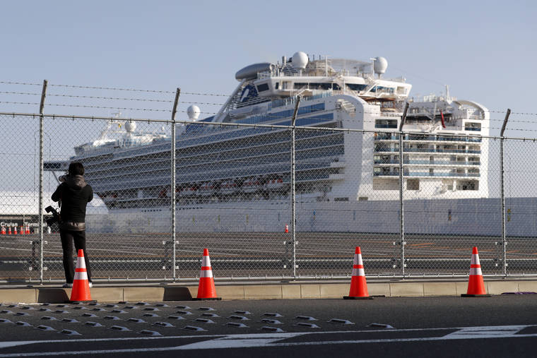 ASSOCIATED PRESS
                                A photographer takes photos near the quarantined Diamond Princess cruise ship anchored at a port in Yokohama, near Tokyo, on Friday.