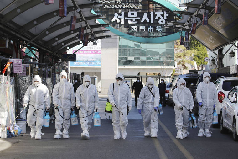 ASSOCIATED PRESS
                                Workers wearing protective gears spray disinfectant as a precaution against the COVID-19 at a local market in Daegu, South Korea, today. South Korea’s president has put the country on its highest alert for infectious diseases and says officials should take “unprecedented, powerful” steps to fight a viral outbreak.