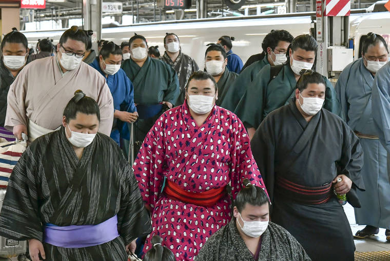 KYODO NEWS VIA ASSOCIATED PRESS
                                Sumo wrestlers wearing masks arrived at Shin Osaka railway station, Sunday, in Osaka, western Japan. A viral outbreak that began in China has infected more than 79,000 people globally.