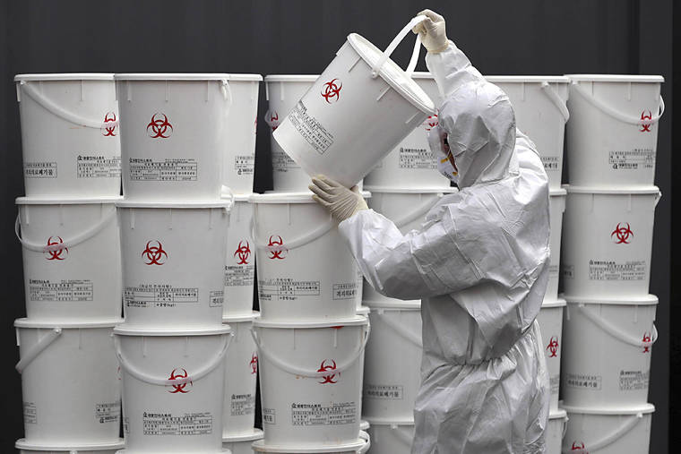 LEE MOO-RYUL/NEWSIS VIA ASSOCIATED PRESS
                                A worker in protective gear stacked plastic buckets containing medical waste from coronavirus patients at a medical center in Daegu, South Korea, Monday. South Korea reported another large jump in new virus cases Monday a day after the president called for “unprecedented, powerful” steps to combat the outbreak that is increasingly confounding attempts to stop the spread.
