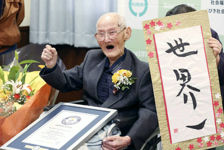 KYODO NEWS VIA AP
                                Chitetsu Watanabe, 112, poses next to the calligraphy he wrote after being awarded as the world’s oldest living male by Guinness World Records, in Joetsu, Niigata prefecture, northern Japan on Feb. 12.