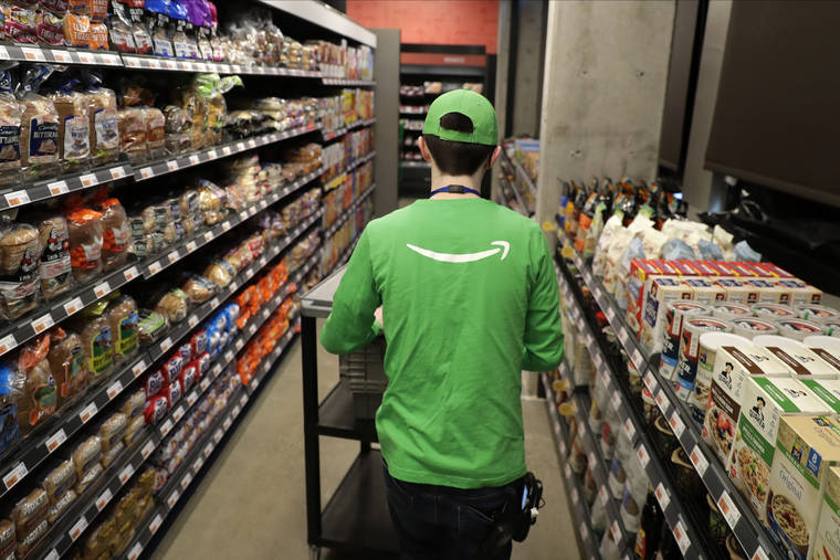 ASSOCIATED PRESS
                                A worker pushes a cart inside an Amazon Go Grocery store set to open soon in Seattle’s Capitol Hill neighborhood.