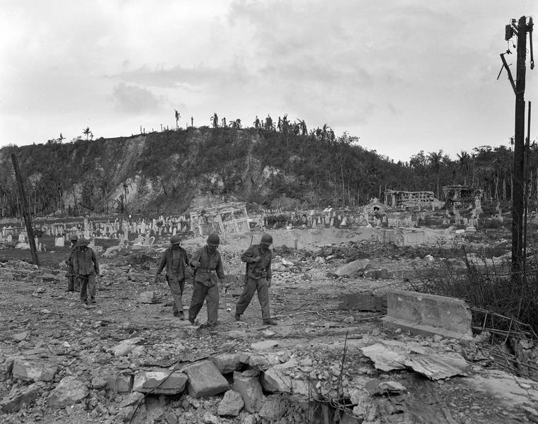 ASSOCIATED PRESS / AUG. 1944
                                U.S. soldiers walked by a bombed-out cemetery in Agana, Guam. The 1941 Japanese invasion of Guam, which happened on the same December day as the attack on Hawaii’s Pearl Harbor, set off years of forced labor, internment, torture, rape and beheadings. Now, more than 75 years later, thousands of people on Guam, a U.S. territory, are expecting to get long-awaited compensation for their suffering at the hands of imperial Japan during World War II.