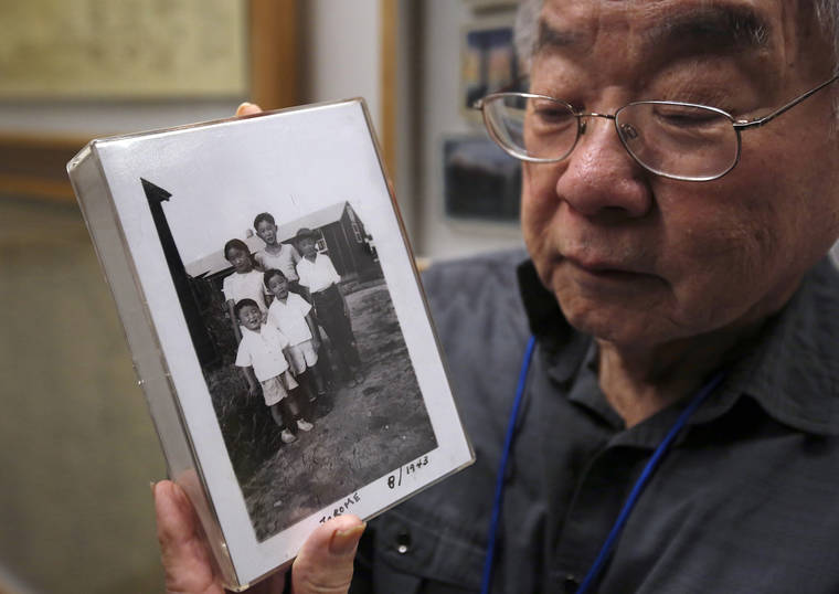 ASSOCIATED PRESS / FEB. 11
                                Les Ouchida holds a 1943 photo of himself, front row, center, and his siblings taken at the internment camp his family was moved to, as he poses at the permanent exhibit titled “UpRooted Japanese Americans in World War II” at the California Museum in Sacramento, Calif. Ochida, who is a docent for the exhibit, and his family were forced to move in 1942 from their home near Sacramento to a camp in Jerome, Arkansas.