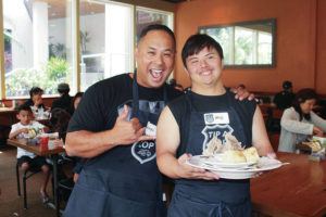 COURTESY SPECIAL OLYMPICS HAWAII
                                Officer Anson “Kaipo” Paiva, left, and Special Olympics athlete Kenji Momohara work the dining room in a Tip a Cop event.