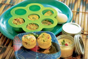 CRAIG T. KOJIMA / CKOJIMA@STARADVERTISER.COM
                                Egg cups filled with roasted peppers, bacon and green onions were made in a silicone mold using a a multicooker, back, and in Mason jars using a sous vide.