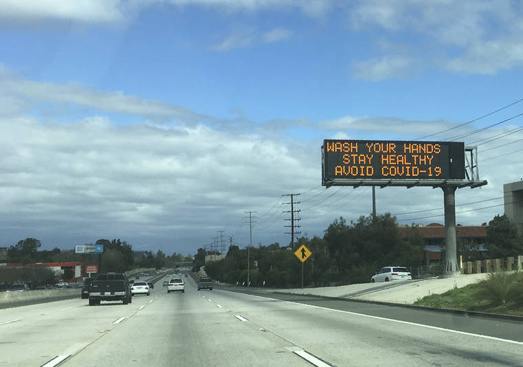 ASSOCIATED PRESS
                                A Caltrans freeway sign reads: “Wash your hands, Stay healthy, Avoid COVID-19” in the San Fernando Valley section of Los Angeles.