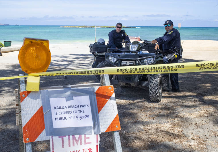 CINDY ELLEN RUSSELL / CRUSSELL@STARADVERTISER.COM
                                Honolulu police officers were on watch at the parking entrance of Kailua Beach Park on Saturday. “It’s like trying to stay dry while standing in the rain,” said one of the officers about keeping the beachgoers away from closed parks due to the COVID-19 pandemic.