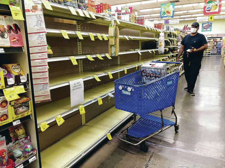 MARK LADAO / MLADAO@STARADVERTISER.COM
                                A shopper looking for rice Saturday at the Times Supermarket on Beretania Street was surprised to find that the store was all out.