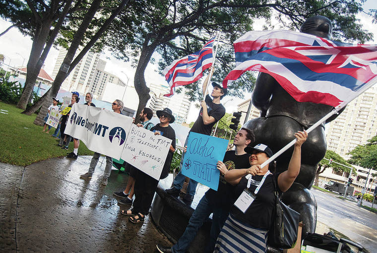 CINDY ELLEN RUSSELL / JAN. 5
                                Supporters of the Thirty Meter Telescope hold signs and flags outside of the Hawai‘i Convention Center. The group greeted participants attending the 235th meeting of the American Astronomical Society, which was held at the convention center in January.