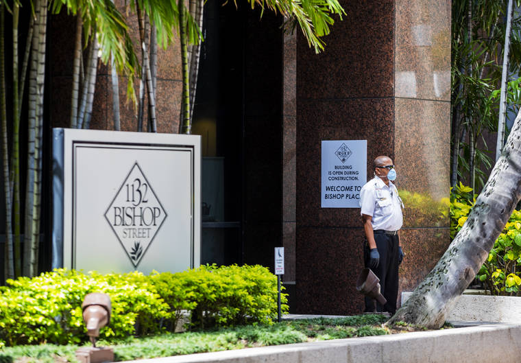 DENNIS ODA / DODA@STARADVERTISER.COM Tenants of the 1132 Bishop St. office building were notified of a worker’s positive coronavirus case. A security guard stands outside the building.