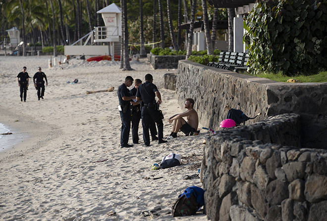 CINDY ELLEN RUSSELL / CRUSSELL@STARADVERTISER.COM
                                Honolulu police officers patrol Waikiki Beach Monday and issue citations to people who allegedly violate the city’s emergency orders. People may cross the sand to enter or exit the water but are not permitted to stay on the beach itself.