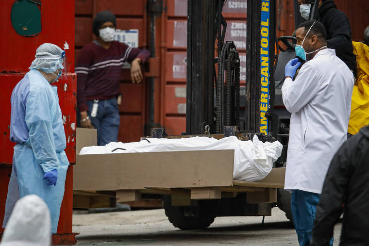 ASSOCIATED PRESS
                                A body wrapped in plastic is prepared to be loaded onto a refrigerated container truck used as a temporary morgue by medical workers due to COVID-19 concerns, Tuesday, at Brooklyn Hospital Center in the Brooklyn borough of New York.