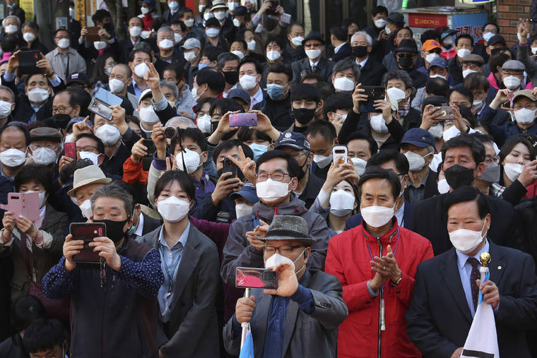 ASSOCIATED PRESS
                                People wearing face masks to help protect against the spread of the new coronavirus listen to a speech of the main opposition United Future Party’s candidate Hwang Kyo-ahn during his campaign for the upcoming parliamentary elections in Seoul, South Korea, today.