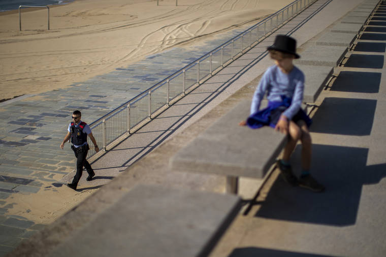 ASSOCIATED PRESS
                                A child looks as a police officer patrols the promenade of the beach, where access is prohibited, in Barcelona, Spain.