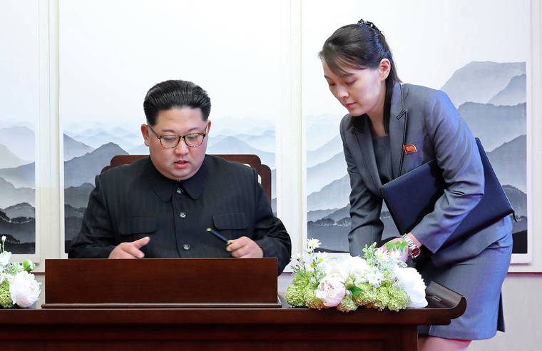 KOREA SUMMIT PRESS POOL VIA AP
                                North Korean leader Kim Jong Un signs a guestbook next to his sister Kim Yo Jong, right, inside the Peace House at the border village of Panmunjom in Demilitarized Zone on April 27, 2018.