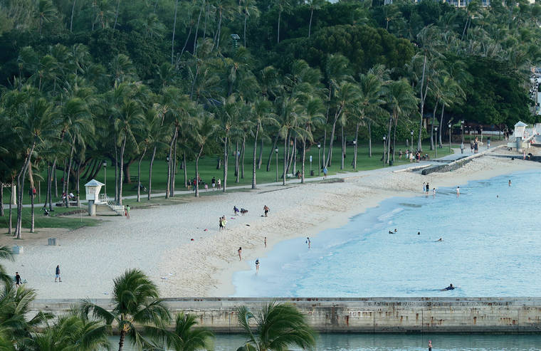 JAMM AQUINO / JAQUINO@STARADVERTISER.COM
                                People are seen on Queen’s Beach on Saturday in Waikiki. Gov. David Ige enforced stricter rules for people heading outside and toward the ocean, closing all beach access except to enter and exit.