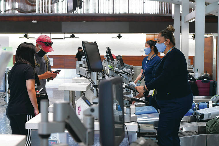 BRUCE ASATO / BASATO@STARADVERTISER.COM
                                Alaska Airlines lead customer service agent Saga Mafi, right foreground, wore a mask as she checked in passengers Jane Oh and Bryan Kim at Daniel K. Inouye International Airport on Friday. In the background is customer service agent Kathy Higashi.