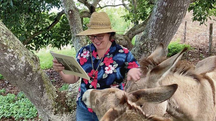 COURTESY FACEBOOK
                                Audrey Blair reads to the resident donkeys at the Kona Historical Society in Captain Cook, Hawaii.
