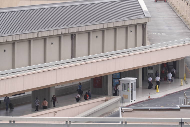 JAMM AQUINO / MARCH 9
                                Travelers walk to their gates at the Daniel K. Inouye International Airport.