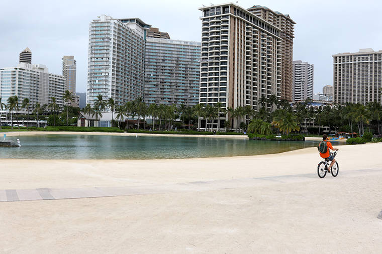 ASSOCIATED PRESS
                                A man rode his bike along the water in a quiet Waikiki last month.