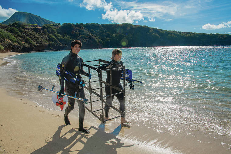 CRAIG T. KOJIMA / CKOJIMA@STARADVERTISER.COM
                                Lab technician Andrew Graham, left, and intern Matt Stefanak of the Coral Reef Ecology Lab of the University of Hawai‘i at Manoa Institute for Marine Biology carried a calibration cube used to take 3-D images and video of the fish at Hanauma Bay.