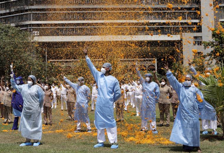ASSOCIATED PRESS / MAY 3
                                An Indian Air Force helicopter showers flower petals on the staff of INS Asvini hospital in Mumbai, India as part of Armed Forces’ efforts to thank the workers, including doctors, nurses and police personnel, who have been at the forefront of the country’s battle against the COVID-19 pandemic. Many cities across the world erupt at sundown with collective cheers thanking front-line workers for their selfless battle. But in Egypt, India, the Philippines, Mexico and elsewhere, doctors have been attacked, intimidated and treated as pariahs because of their work.
