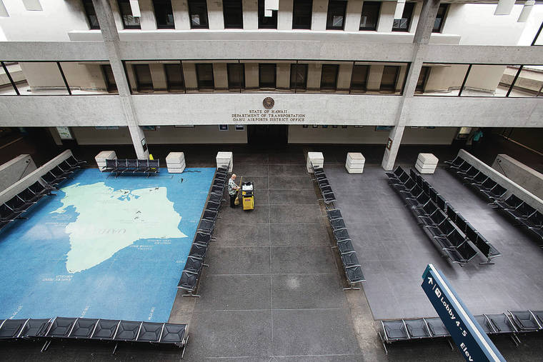 CINDY ELLEN RUSSELL / CRUSSELL@STARADVERTISER.COM
A maintenance employee worked Monday in a deserted lobby at Daniel K. Inouye International Airport.