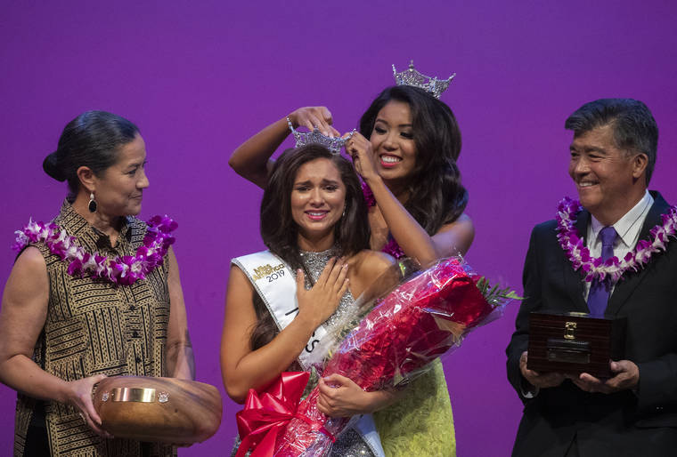 CINDY ELLEN RUSSELL / CRUSSELL@STARADVERTISER.COM
                                Nikki Holbrook reacted as she was crowned Miss Hawaii 2019 at the Miss Hawaii Scholarship Program held on June 15. Pinning the crown is Miss Hawaii 2018 Penelope Ng Pack. Also pictured is Debbie Nakanelua-Richards, Miss Hawaii 1984, and Randy Nishii. The three women contributred to an imaginative music video with other Miss Hawaii winners.