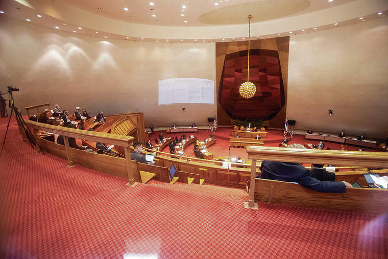 CINDY ELLEN RUSSELL / CRUSSELL@STARADVERTISER.COM
                                Hawaii lawmakers were seated in the public gallery Monday to maintain social distancing in the House of Representatives chamber while in session on the opening day of the Legislature. The state Capitol was closed to the media and public.