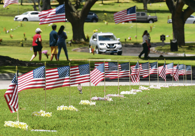 BRUCE ASATO / BASATO@STARADVERTISER.COM
                                Scouts decorated every grave at the National Memorial Cemetery of the Pacific with flags and plumeria lei Sunday. The 71st Mayor’s Memorial Day Ceremony, which was set for today, is canceled.
