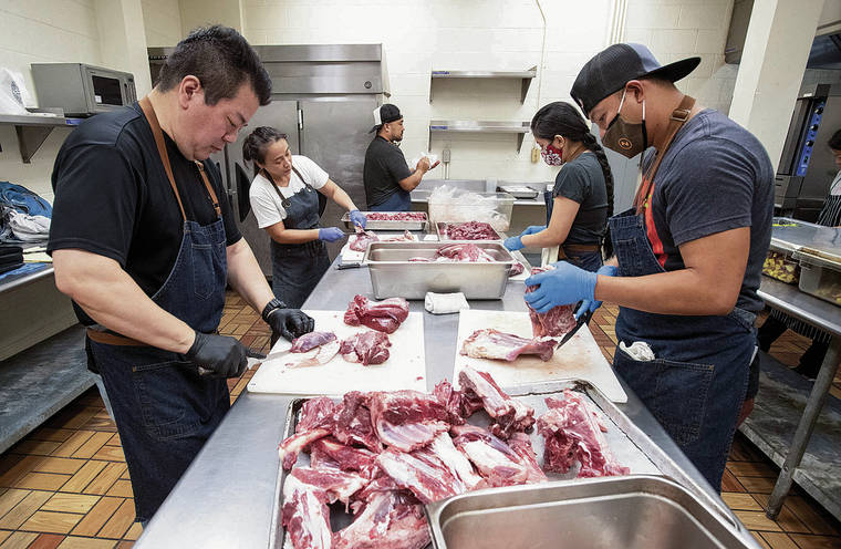 CINDY ELLEN RUSSELL / CRUSSELL@STARADVERTISER.COM 
                                Paul Matsumoto, Alan Wong’s chef de cuisine, prepares venison for curry with volunteers at the Pacific Gateway Center. Pictured are Matsumoto, left, Regina Lapian, David Lukela, Camille Cadiz and Johnver Invencion.