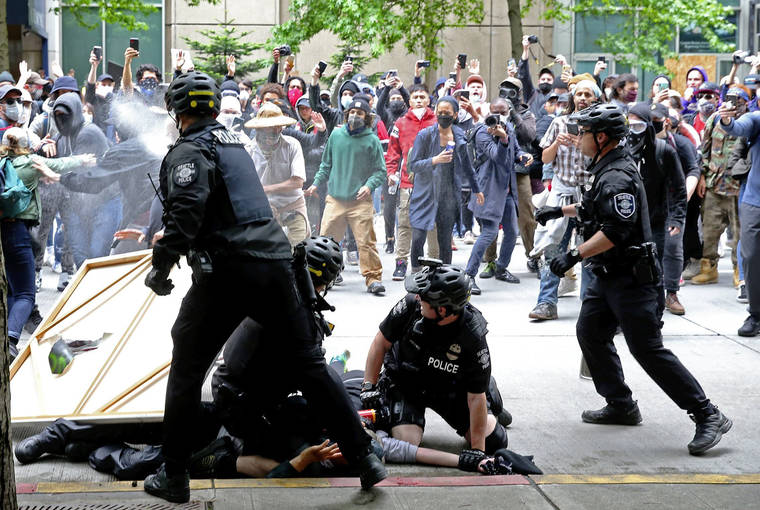 THE SEATTLE TIMES VIA ASSOCIATED PRESS
                                Protesters surrounding police officers making an arrest are pepper sprayed in downtown Seattle during demonstrations over the death of George Floyd on May 31.