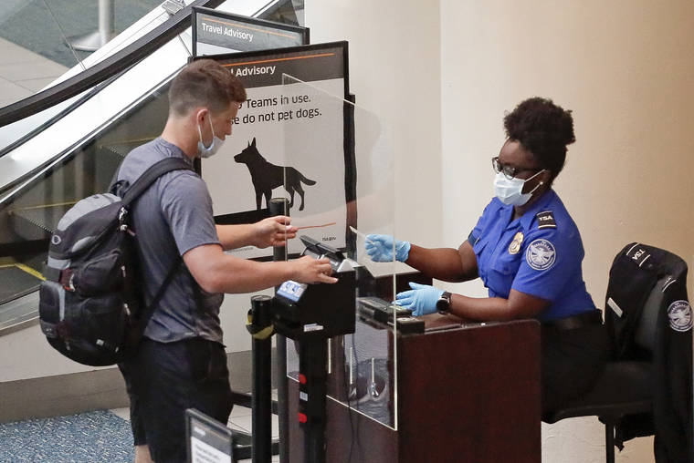 ASSOCIATED PRESS
                                A TSA worker, right, checked a passenger before entering a security screening, June 17, at Orlando International Airport in Orlando, Fla. A high-ranking Transportation Security Administration official said the agency is falling short when it comes to protecting airport screeners and the public from the new coronavirus, according to published reports.