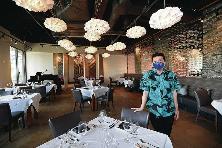 BRUCE ASATO / BASATO@STARADVERTISER.COM
                                Chef Chai Chaowasaree has spread out the tables at his restaurant, Chef Chai, to allow for social distancing rules as he prepares to reopen his dining room Friday.