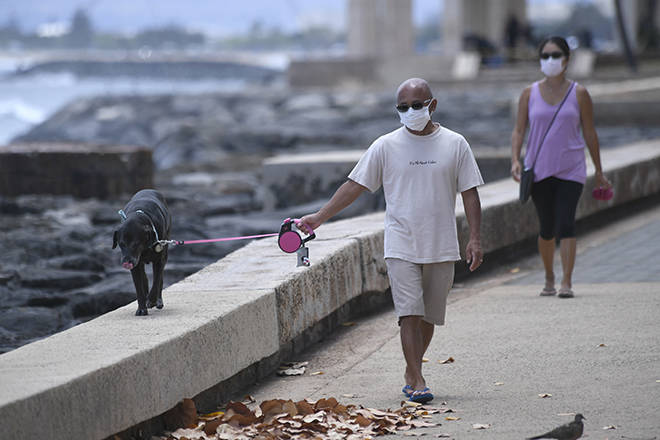 BRUCE ASATO / BASATO@STARADVERTISER.COM
                                State and local leaders and medical professionals urge the public to continue following safety guidelines to keep Hawaii’s COVID-19 infection rate low. Greg and Yasuko Murata wore face masks Sunday as they took their dog, Hime, out for his regular walk for exercise along the promenade at Kakaako Waterfront Park.