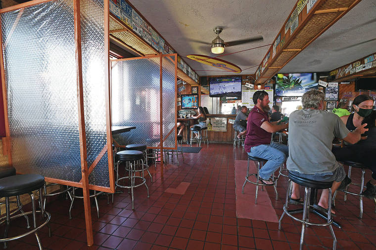 BRUCE ASATO / BASATO@STARADVERTISER.COM
                                Plastic shields have been put up between tables against a wall to provide a barrier between groups seated at tables. The Shack Kailua has also moved tables farther away from others for distancing.