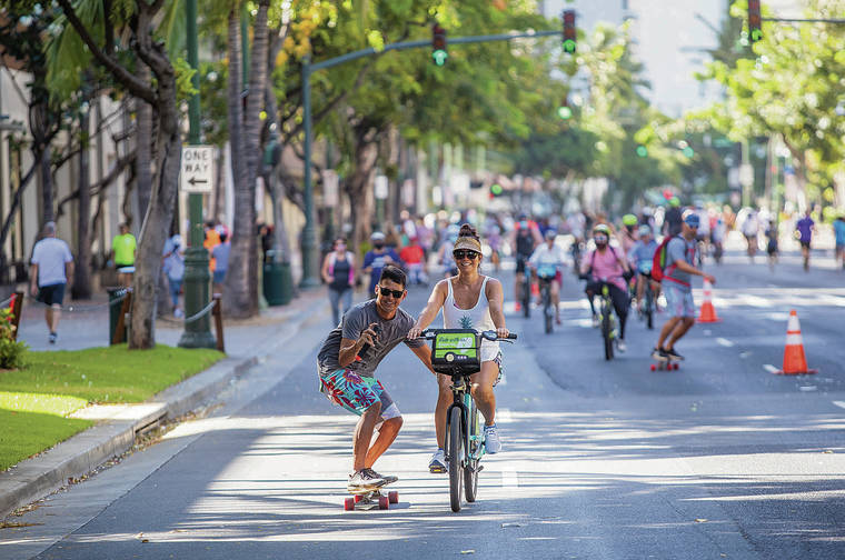 DENNIS ODA / DODA@STARADVERTISER.COM
                                Keoni Ching took a video of himself being towed by Jes Schlais on Sunday, when Kalakaua Avenue in Waikiki was closed to vehicular traffic and reserved for walkers, joggers, bicyclists — and skateboarders.