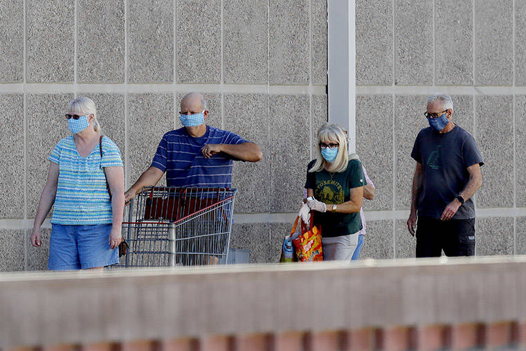 ASSOCIATED PRESS
                                Customers wear masks as they wait to enter a store Wednesday in Tempe, Ariz. A group of Arizona medical professionals is urging Republican Gov. Doug Ducey to take steps like requiring masks in public to slow a major increase in new coronavirus cases that has made the state a national hot spot.