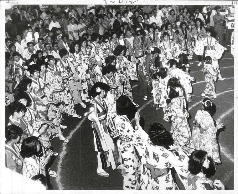 STAR-ADVERTISER ARCHIVE
                                6/29/62
                                Triple rings of dancers circle the “kagura” (raised platform) during Obon time at Wailuku Hongwanji Mission.