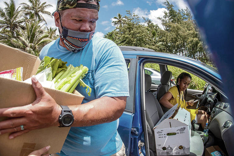 CINDY ELLEN RUSSELL / CRUSSELL@STARADVERTISER.COM
                                Volunteer Shawn Chang loaded boxes of food into Yanique Hadley’s vehicle at the Ohana food distribution held Monday at the Hauula Civic Center.