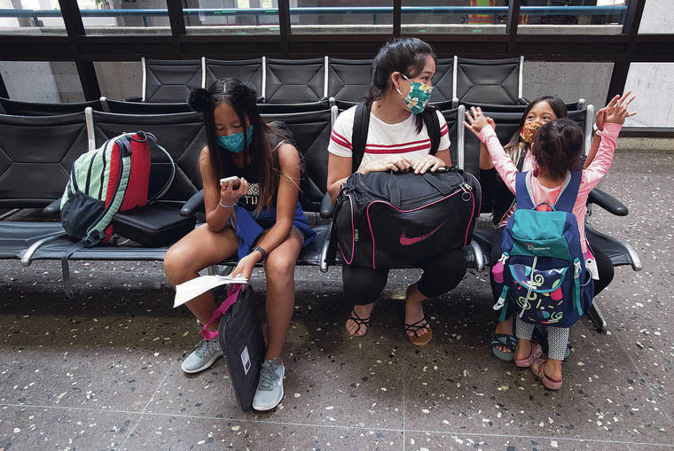CINDY ELLEN RUSSELL / CRUSSELL@STARADVERTISER.COM 
                                Randall Fermin’s clan includes Madison Fermin, 13, left, her cousin Jessica Dixon, 16, and sisters Makanalani, 8, and Mallory Grace, 3. They waited at the airport Tuesday.