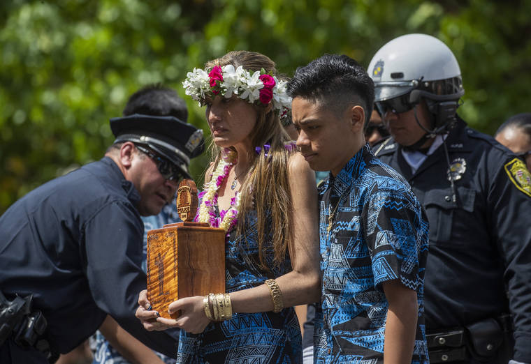 CINDY ELLEN RUSSELL / CRUSSELL@STARADVERTISER.COM
                                Ka‘ohinani Kalama holds her husband’s urn with her son, Kaumana, during the Honolulu Police Department’s roll call ceremony held for officer Kaulike Kalama on March 7.